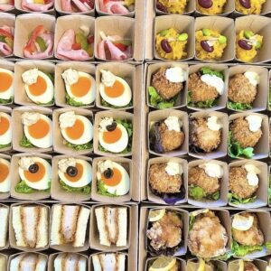 松山市のケータリングで人気のオードブル盛り合わせ。卵の前菜やからあげ、サンドイッチなど多彩なパーティー料理が美しく並ぶ、ミスタービュッフェ愛媛のオードブルデリバリー事例