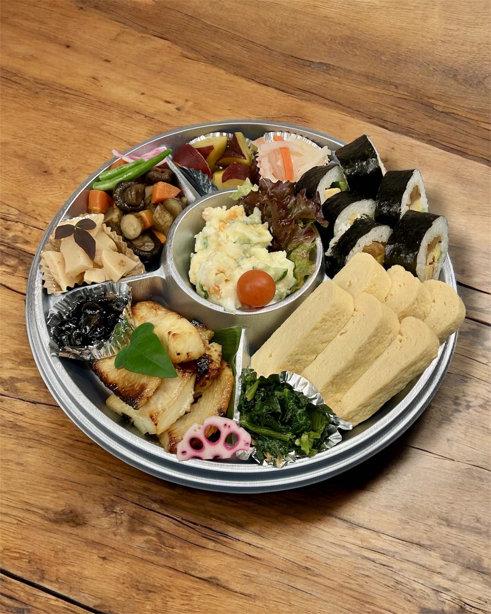 だし巻き・煮物・酢の物・焼き魚・巻き寿司入りの和風オードブル丸皿