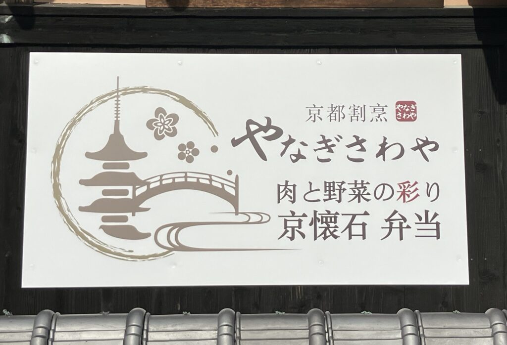 京都割烹やなぎさわや本店の外観看板。京懐石弁当や肉と野菜の彩りを表現した店舗ロゴ。
