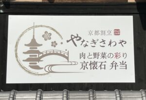 京都割烹やなぎさわや本店の外観看板。京懐石弁当や肉と野菜の彩りを表現した店舗ロゴ。