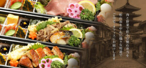 松山市の街並みを背景に、肉と野菜が彩る京懐石弁当が重箱で並んでいる。用途に応じて自宅やオフィスにも配送。